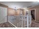 Upstairs hallway with contemporary lighting fixture, neutral paint and carpet, and white banister at 5139 W Shumway Farm Rd, Laveen, AZ 85339