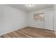 Empty bedroom featuring wood floors, a bright window, and a white painted door at 520 N Stapley Dr # 123, Mesa, AZ 85203
