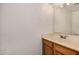 Bathroom with a light countertop sink and wooden cabinets at 6857 S Roosevelt St, Tempe, AZ 85283