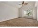 Spacious carpeted bedroom with vaulted ceilings, a ceiling fan, and a large window at 6857 S Roosevelt St, Tempe, AZ 85283