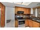 Kitchen featuring wood cabinets, black countertops, and stainless steel appliances at 6857 S Roosevelt St, Tempe, AZ 85283