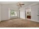 Spacious carpeted main bedroom with vaulted ceilings, a ceiling fan, and a large window at 6857 S Roosevelt St, Tempe, AZ 85283