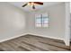 A bright bedroom with sleek wood floors, neutral paint, a window, and a ceiling fan at 7952 W Oregon Ave, Glendale, AZ 85303