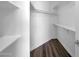 The closet features dark wood flooring and is neatly organized with white shelves and hanging rods at 7952 W Oregon Ave, Glendale, AZ 85303