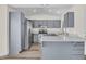 Spacious kitchen boasts stainless steel appliances, blue cabinets, quartz countertops and ample natural light, a chef's dream at 7952 W Oregon Ave, Glendale, AZ 85303