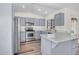 Updated kitchen with stainless steel appliances, gray cabinetry, quartz countertops, and seamless access to the dining area at 7952 W Oregon Ave, Glendale, AZ 85303