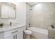 Well-lit bathroom with a marble vanity, gold fixtures, and a bathtub-shower combination with tiled walls at 7955 E Chaparral Rd # 116, Scottsdale, AZ 85250