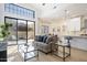 Bright living room with modern furnishings, glass coffee table, and access to an outdoor patio at 7955 E Chaparral Rd # 116, Scottsdale, AZ 85250