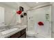 This bathroom features a granite counter top, storage shelves, and a glass enclosed shower for a relaxing at home spa at 8046 W Agora Ln, Phoenix, AZ 85043