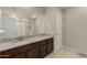 This bathroom offers granite countertops and a large mirror above a vanity with cabinets for plenty of storage at 8046 W Agora Ln, Phoenix, AZ 85043