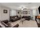 Spacious living room with leather sofas, patterned drapes, ceiling fan, and carpeted floors at 8046 W Agora Ln, Phoenix, AZ 85043