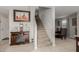 View of carpeted staircase, adjacent to dining area, with decorative furniture and artwork at 8046 W Agora Ln, Phoenix, AZ 85043