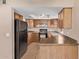 Well-lit kitchen with wood cabinets, black appliances, and neutral countertops at 925 S Longmore -- # 210, Mesa, AZ 85202