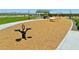 Spring toy on playground with mulch, sidewalk, grass, green trees, and a shade structure at 15154 W Gray Fox Trl, Surprise, AZ 85387