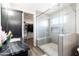 Bathroom with dark vanity, walk-in closet, and gray tiled shower enclosure at 34949 N Donald Way, San Tan Valley, AZ 85140