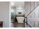 Luxurious bathroom with a modern soaking tub, a glass-enclosed shower, and stylish barn door entry at 34949 N Donald Way, San Tan Valley, AZ 85140