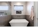Contemporary bathroom showcasing a freestanding tub, a frameless shower, and chic gray tiling for a modern look at 34949 N Donald Way, San Tan Valley, AZ 85140