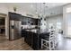 Stylish kitchen with dark cabinetry, a large island, and a seamless connection to the dining area at 34949 N Donald Way, San Tan Valley, AZ 85140