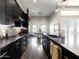 Contemporary kitchen featuring black cabinets, marble counters, stainless appliances, and open dining area at 34949 N Donald Way, San Tan Valley, AZ 85140