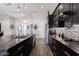 Modern kitchen boasts sleek black cabinets, marble countertops, stainless steel appliances and designer backsplash at 34949 N Donald Way, San Tan Valley, AZ 85140