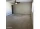 Bright living room featuring a ceiling fan, large window, and neutral carpeting at 4741 W Annette Cir, Glendale, AZ 85308