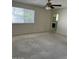 Large living room with neutral carpeting, a ceiling fan, and a window overlooking the backyard at 4741 W Annette Cir, Glendale, AZ 85308