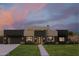 Striking contemporary home boasts clean lines, neutral tones, and lush landscaping against a colorful dusk sky at 5439 E Bloomfield Rd, Scottsdale, AZ 85254