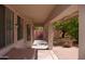 Covered patio with brick accents, offering a relaxing outdoor space with views of the backyard and mature trees at 2123 W Maldonado Rd, Phoenix, AZ 85041