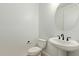 Modern powder room featuring pedestal sink, round mirror, and a toilet at 23724 N 165Th Dr, Surprise, AZ 85387