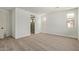 A spacious bedroom featuring carpet flooring, neutral paint, and multiple windows for natural light at 23724 N 165Th Dr, Surprise, AZ 85387