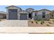 Charming, light-colored single-Gathering home featuring a large garage, front yard landscaping, and a paver driveway at 23724 N 165Th Dr, Surprise, AZ 85387