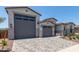 Spacious three-car garage and gray brick driveway offer ample parking and curb appeal at 23724 N 165Th Dr, Surprise, AZ 85387