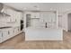 Bright, modern kitchen featuring white cabinets, subway tile backsplash, stainless steel appliances, and a large central island at 23724 N 165Th Dr, Surprise, AZ 85387