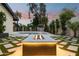 A backyard featuring a modern fire pit area with integrated lighting and lush landscaping at 4316 N 86Th Pl, Scottsdale, AZ 85251
