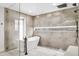Modern bathroom featuring a luxurious soaking tub, walk-in shower, and neutral tile surround at 4316 N 86Th Pl, Scottsdale, AZ 85251
