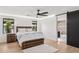 Bright bedroom features hardwood floors, ceiling fan, and an ensuite bathroom with sliding barn door at 4316 N 86Th Pl, Scottsdale, AZ 85251