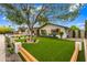 Charming home with lush, green landscaping, rustic shutters, and a wood and post fence along the front of the yard at 4316 N 86Th Pl, Scottsdale, AZ 85251