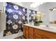 Bathroom with dual vanity, floral shower curtain, and bright lighting creating a welcoming atmosphere at 5424 S 15Th St, Phoenix, AZ 85040