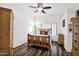 Cozy bedroom featuring laminate flooring, a ceiling fan, wood furnishings, and lots of natural light at 5424 S 15Th St, Phoenix, AZ 85040