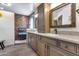 Bathroom featuring a wooden vanity with double sinks and a shower with chevron-patterned tile at 8246 W Melinda Ln, Peoria, AZ 85382