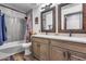 Bathroom featuring dual sinks, neutral colors, modern fixtures, and tiled shower at 8246 W Melinda Ln, Peoria, AZ 85382