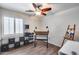 Bedroom with a ceiling fan, window with plantation shutters, black shelving, and an easel at 8246 W Melinda Ln, Peoria, AZ 85382