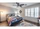 Cozy bedroom with stylish ceiling fan, plantation shutters, and unique decor at 8246 W Melinda Ln, Peoria, AZ 85382