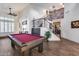 Spacious game room features a pool table, high ceilings, and staircase with stone accent wall at 8246 W Melinda Ln, Peoria, AZ 85382