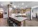 Charming kitchen with brick accents on the island, stainless steel appliances, and granite countertops at 8246 W Melinda Ln, Peoria, AZ 85382