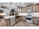 Updated kitchen with stainless steel appliances, granite countertops, and stone accents on the island at 8246 W Melinda Ln, Peoria, AZ 85382