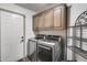 Well-equipped laundry room with modern appliances and ample storage cabinets at 8246 W Melinda Ln, Peoria, AZ 85382