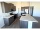 Modern kitchen features an island with quartz countertop, sleek appliances, gray cabinets, and wood-look tile floors at 6023 N Nigal Rd, Casa Grande, AZ 85122