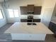 Bright kitchen features a spacious quartz island, modern appliances, and stylish gray cabinetry at 6023 N Nigal Rd, Casa Grande, AZ 85122