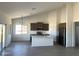 Open-concept kitchen boasts gray cabinets, a quartz countertop island, stainless steel appliances, and modern lighting at 6023 N Nigal Rd, Casa Grande, AZ 85122